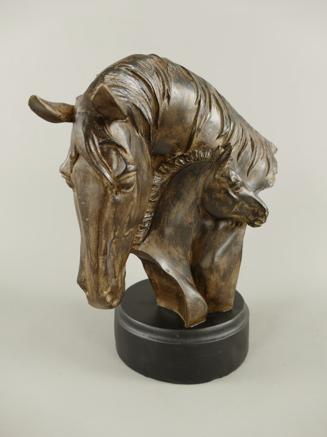 Paardenhoofd polystone bronskleur 3 Paardenhoofd polystone bruin/gekleurd hout. Het beeld toont twee hoofden: een moeder en haar veulen, die op een elegante sokkel rusten.