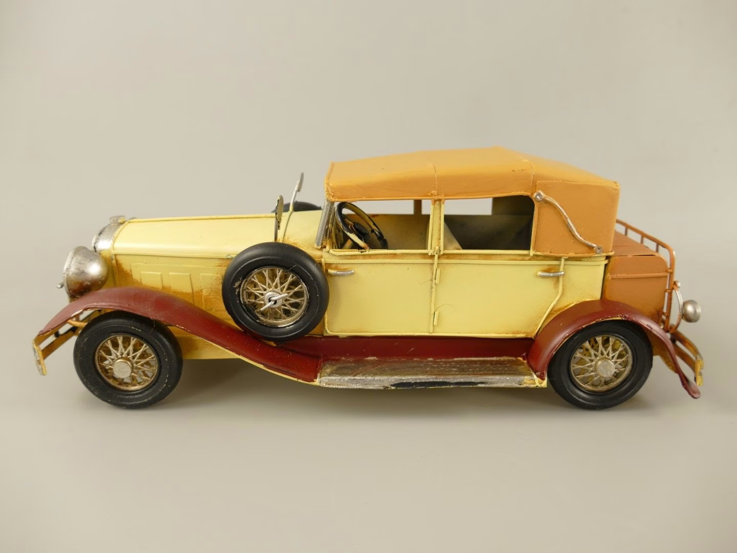 Antieke Okergele Oldtimer – Metalen Auto met Reservewiel – 33 cm 1 Okergele Antieke Oldtimer Auto oldtimer van ijzer met bordeauxrode spatborden en reservewiel – decoratie 33 cm.